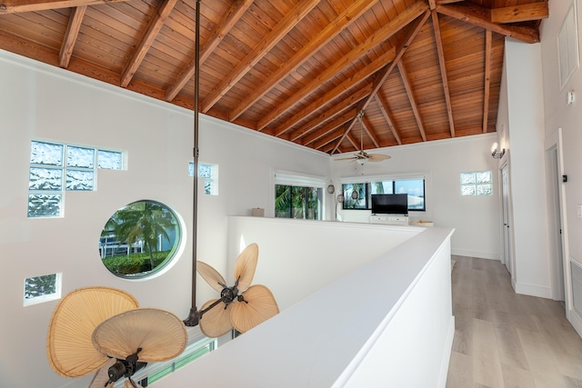 interior space featuring wood ceiling, beamed ceiling, light wood-style flooring, and baseboards