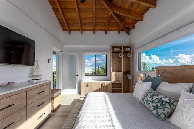 bedroom with lofted ceiling with beams, wooden ceiling, and light wood-style floors