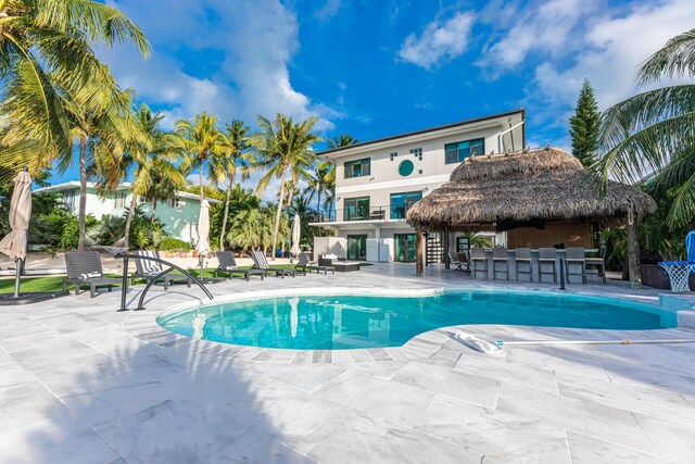 view of pool featuring exterior bar and a patio area