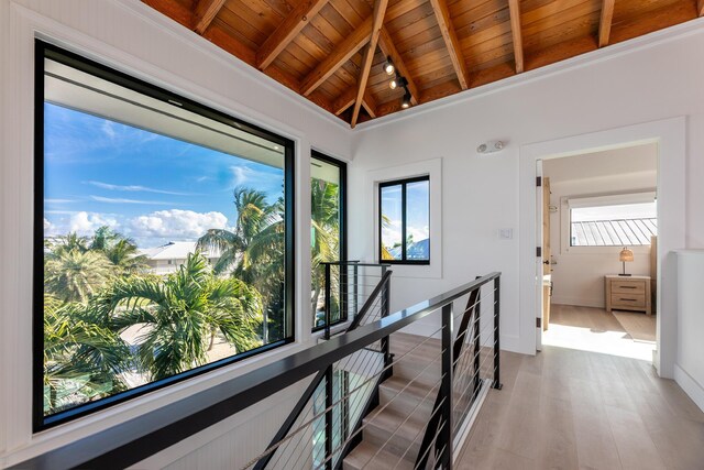 hallway with wooden ceiling, wood finished floors, a wealth of natural light, and an upstairs landing