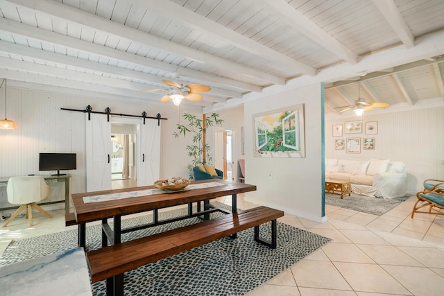 dining area featuring a ceiling fan, beam ceiling, light tile patterned floors, and a barn door