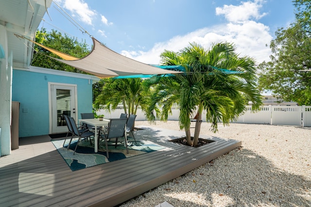 wooden deck featuring outdoor dining space and a fenced backyard