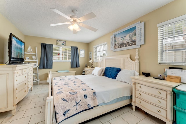 bedroom featuring ceiling fan, a textured ceiling, and light tile patterned flooring