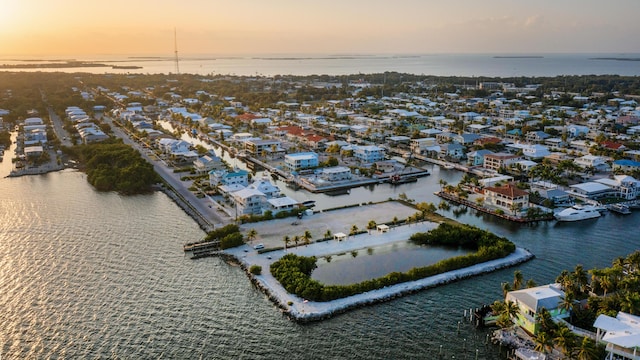 aerial view at dusk featuring a water view