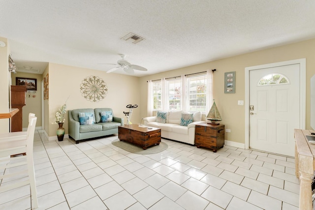 living room featuring light tile patterned floors, a textured ceiling, and ceiling fan