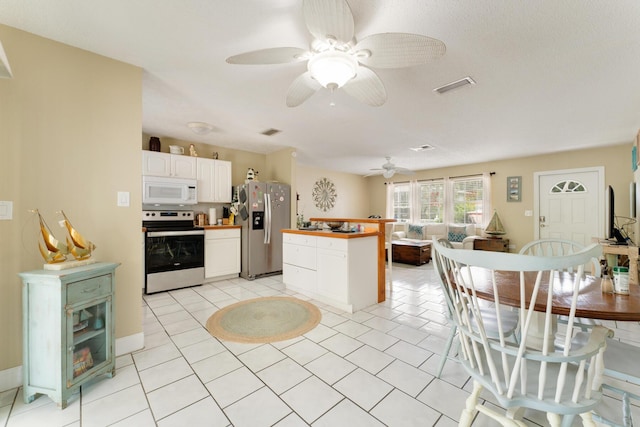 kitchen with white cabinetry, light tile patterned floors, stainless steel appliances, and ceiling fan