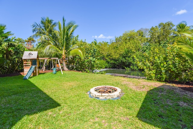 view of yard featuring a playground and an outdoor fire pit