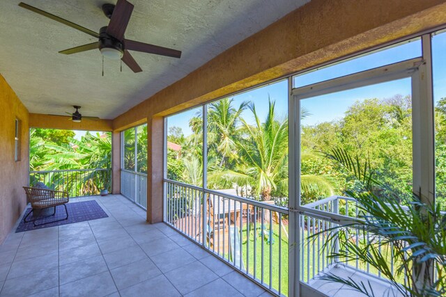 unfurnished sunroom with ceiling fan