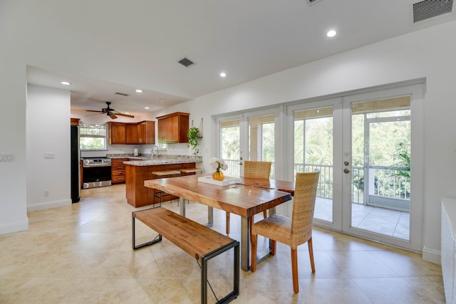 dining area featuring french doors, sink, and light tile patterned floors