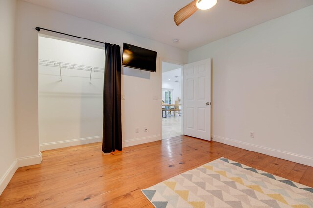 unfurnished bedroom with ceiling fan, light hardwood / wood-style floors, and a closet