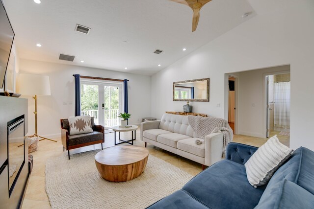 tiled living room featuring french doors and high vaulted ceiling