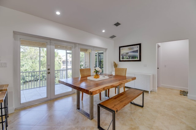 dining room featuring french doors, vaulted ceiling, and light tile patterned floors