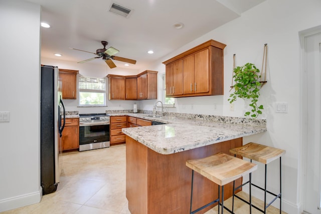 kitchen featuring stainless steel appliances, sink, a kitchen breakfast bar, and kitchen peninsula