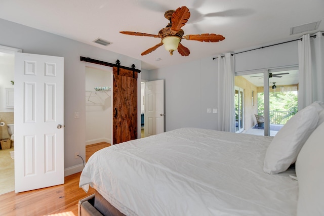 bedroom featuring a barn door, access to exterior, ceiling fan, and light hardwood / wood-style flooring