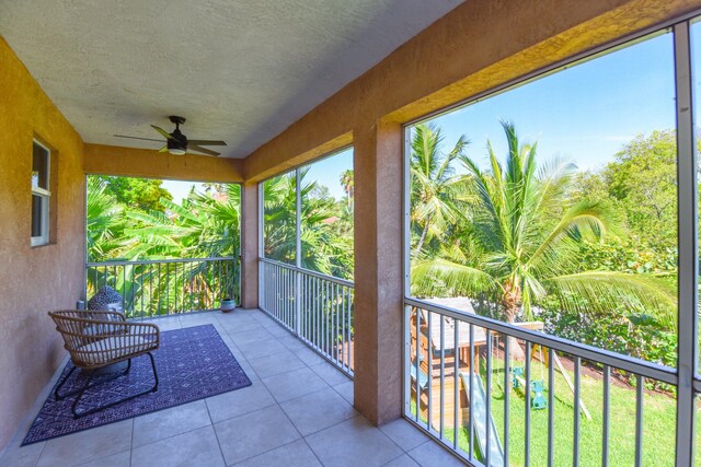 unfurnished sunroom with ceiling fan