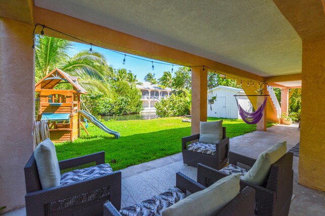 view of patio featuring a shed, an outdoor living space, and a playground