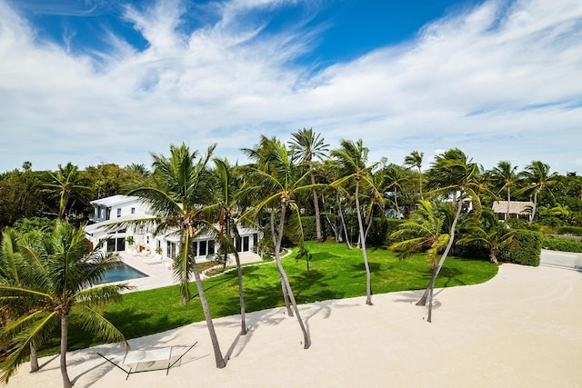 view of property's community with a yard, a swimming pool, and a patio area