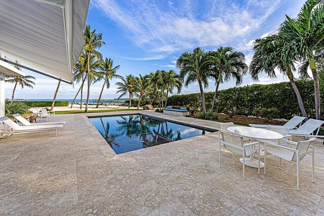 view of swimming pool featuring a patio area and a water view