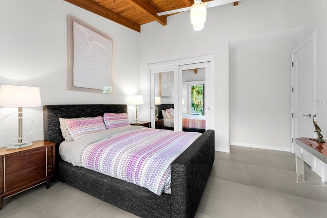 bedroom with beamed ceiling, tile patterned flooring, and wooden ceiling