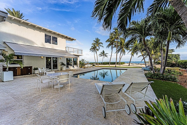 view of pool featuring a patio area and a water view