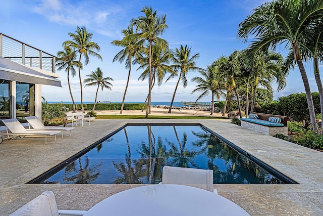 view of pool with a jacuzzi, a patio, and a water view