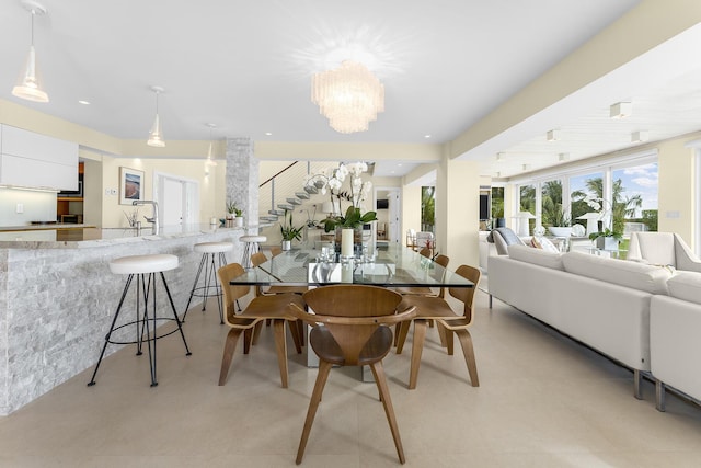 dining space with sink and an inviting chandelier