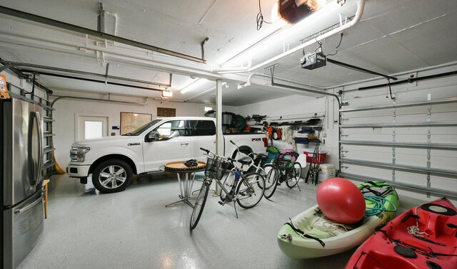 garage featuring a garage door opener and stainless steel fridge