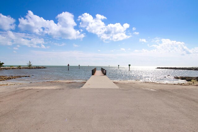 view of dock with a water view and a view of the beach