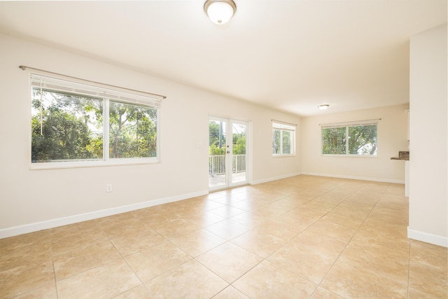 empty room with french doors and light tile patterned floors