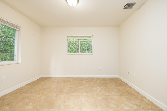 tiled spare room featuring a wealth of natural light