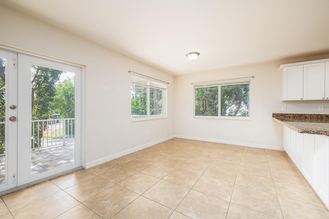 unfurnished dining area featuring light tile patterned flooring