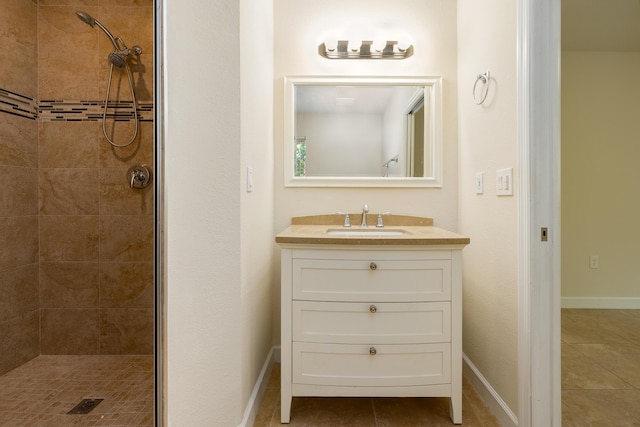 bathroom with vanity, tile patterned flooring, and tiled shower