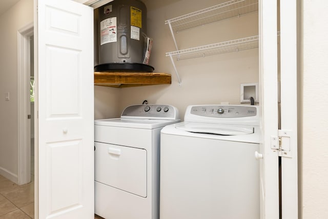 washroom featuring separate washer and dryer, electric water heater, and light tile patterned floors