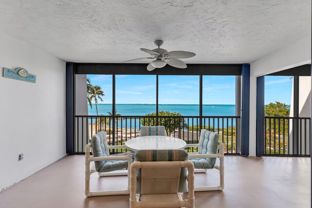 sunroom with a water view, plenty of natural light, and ceiling fan