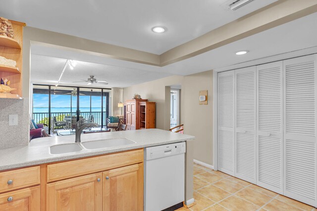 kitchen with light brown cabinetry, sink, light tile patterned floors, white dishwasher, and ceiling fan