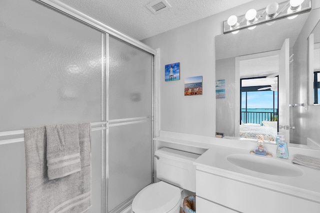 bathroom with vanity, toilet, a textured ceiling, and walk in shower