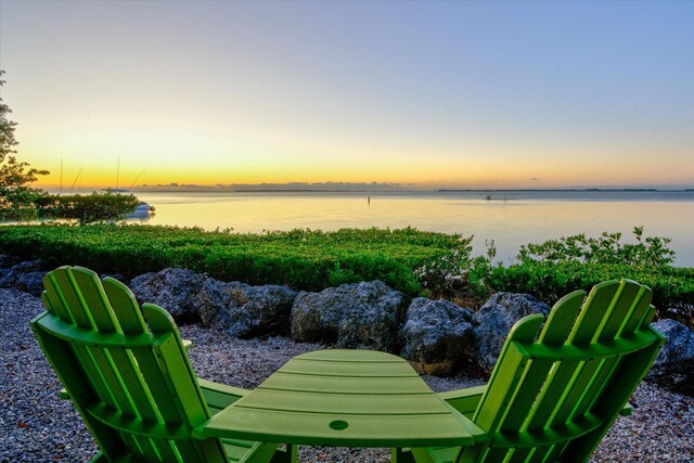 yard at dusk featuring a water view