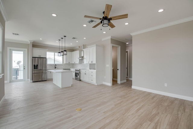 23066 Tarpon Ln, Cudjoe, FL 33042 - kitchen featuring appliances with stainless steel finishes, open floor plan, a kitchen island, ornamental molding, and baseboards