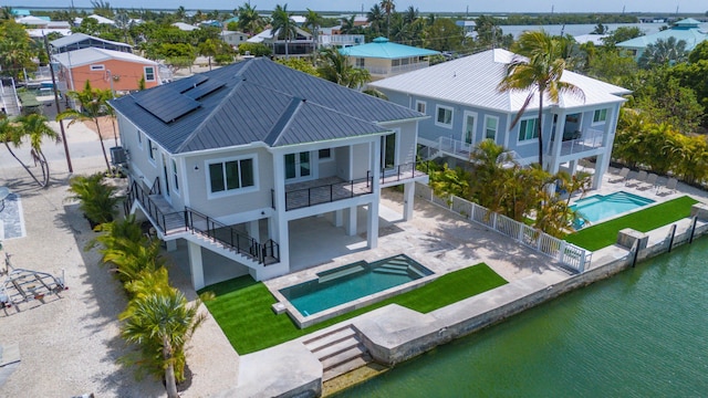 23066 Tarpon Ln, Cudjoe, FL 33042 - back of house with stairway, a hot tub, a balcony, a fenced backyard, and metal roof