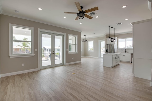 23066 Tarpon Ln, Cudjoe, FL 33042 - unfurnished living room featuring ceiling fan, crown molding, french doors, baseboards, and light wood finished floors