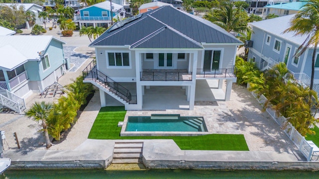 23066 Tarpon Ln, Cudjoe, FL 33042 - rear view of property with stairway, a standing seam roof, metal roof, an outdoor pool, and a patio area