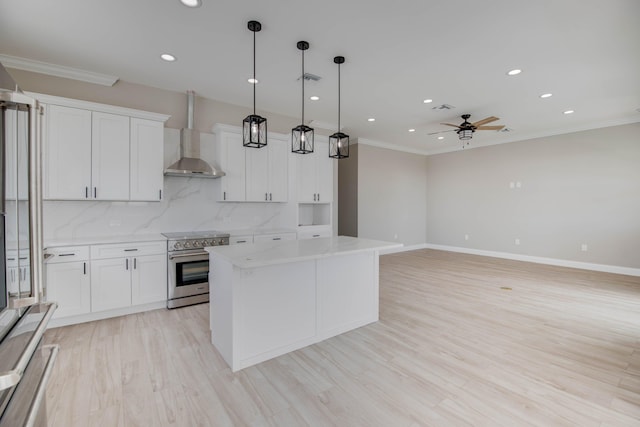 23066 Tarpon Ln, Cudjoe, FL 33042 - kitchen featuring high end range, ornamental molding, ceiling fan, wall chimney range hood, and a kitchen island