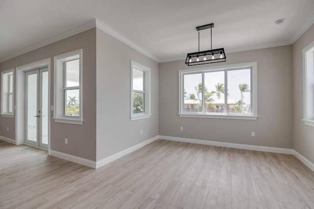 23066 Tarpon Ln, Cudjoe, FL 33042 - spare room with light wood-type flooring, plenty of natural light, crown molding, baseboards, and french doors