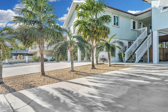 918 W Ocean Dr, Key Colony, FL 33051 - view of front of house with stairs, driveway, a carport, and stucco siding