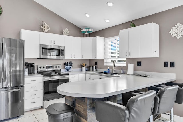918 W Ocean Dr, Key Colony, FL 33051 - kitchen featuring stainless steel appliances, a sink, a kitchen bar, a peninsula, and light countertops