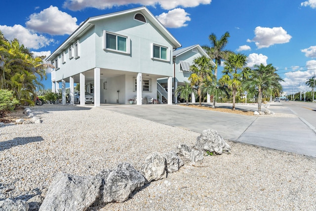 918 W Ocean Dr, Key Colony, FL 33051 - view of front of house with a carport, stairs, concrete driveway, and stucco siding