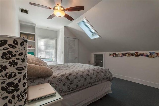 bedroom with carpet floors, vaulted ceiling with skylight, and ceiling fan