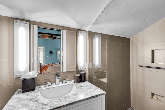 bathroom featuring vanity, lofted ceiling, tile walls, and ceiling fan