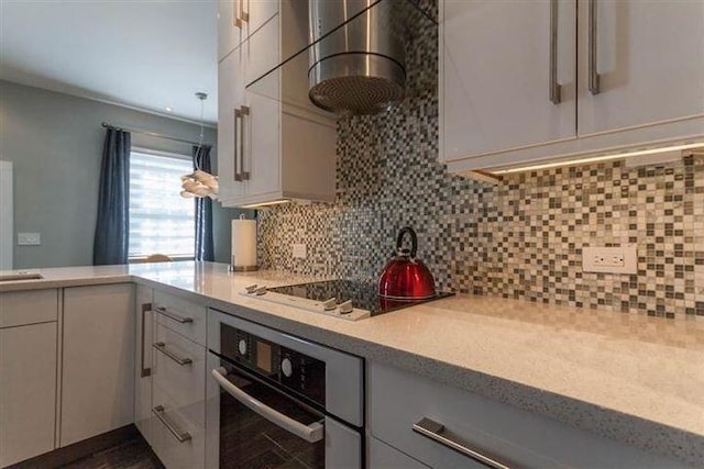 kitchen with backsplash, white cabinets, black electric cooktop, oven, and wall chimney exhaust hood