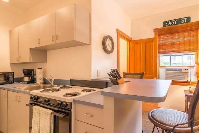 kitchen featuring a breakfast bar, sink, white cabinetry, electric range oven, and cooling unit